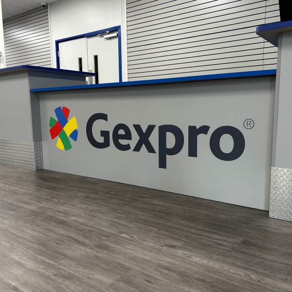 Custom reception desk wall graphic with client logo installed by Signarama
